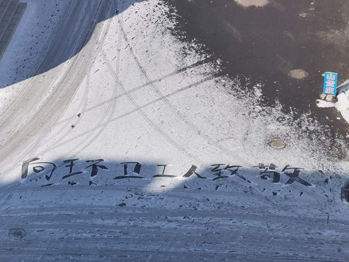 书法爱好者在雪地上书写“向环卫工人致敬”.jpg